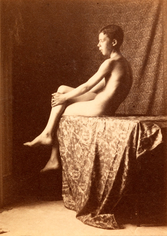 Boy nude, sitting on draped table in front of printed-fabric backdrop (Нагой мальчик, сидящий на драпированном столе перед фоном из печатной ткани), c.1885