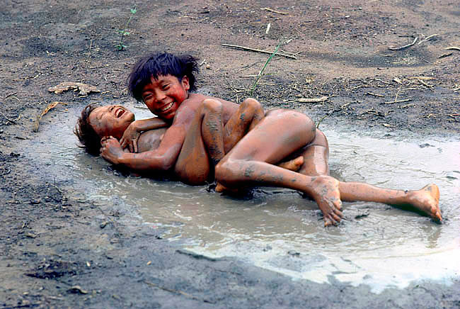 Yanomami Indian boys playing the middle of the yano, the vast circular communal house of the clan (Мальчики племени яномами играют в середине Яно, обширного круга общинного дома клана)