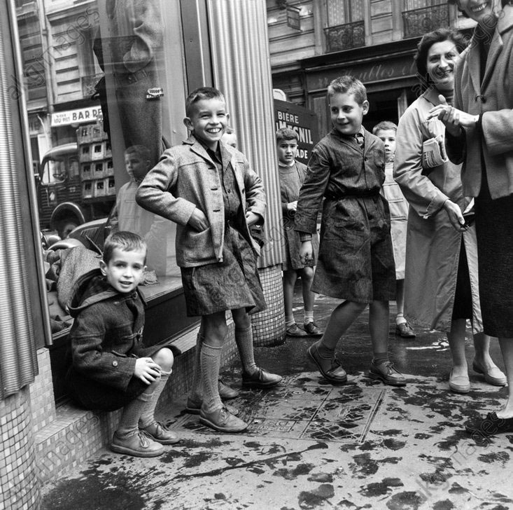 Two boys in new jackets, in front of the clothing store with their mothers (Два мальчика в новых куртках, со своими матерями перед магазином одежды), c.1950s