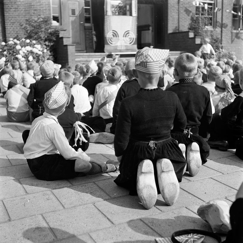 Festivities (Liberation WW2). Children with wooden shoes looking at puppet theatre (Праздник освобождения. Дети в деревянных башмаках смотрят кукольное представление), July 1945