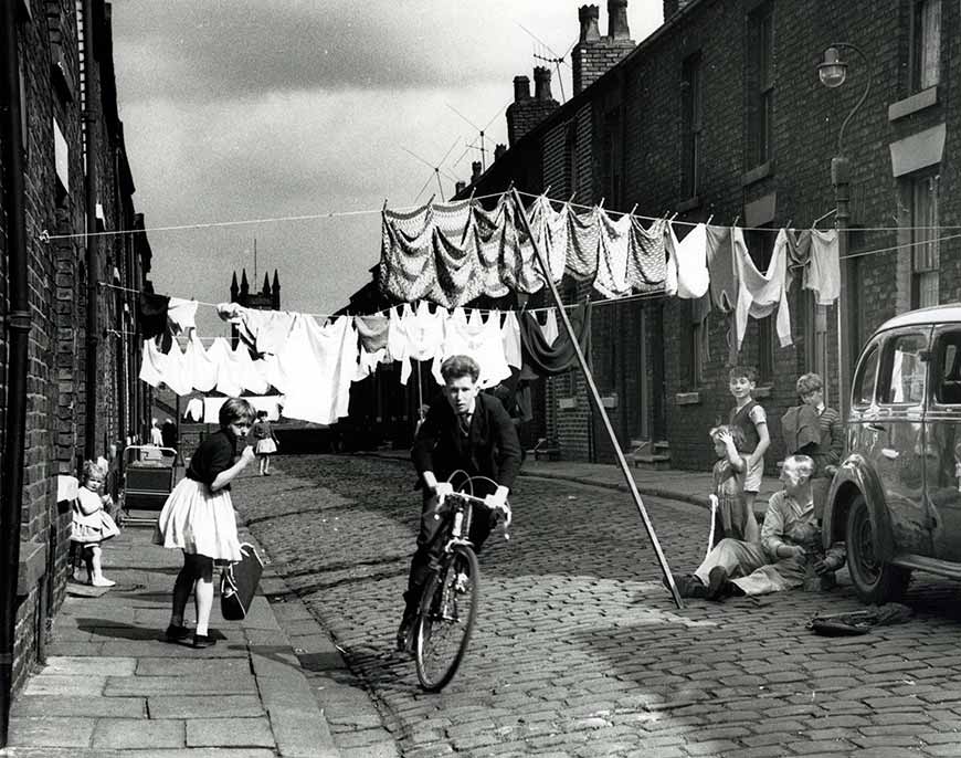 Cycling along a terraced street (Поездка на велосипеде по улице с таунхаусами), 1962