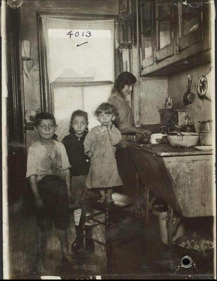 A mother and her three children in their tenements kitchen (Мать и ее трое детей на своей кухне в многоквартирном доме), 1915