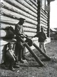 Peasant grinding an ax on an emery wheel