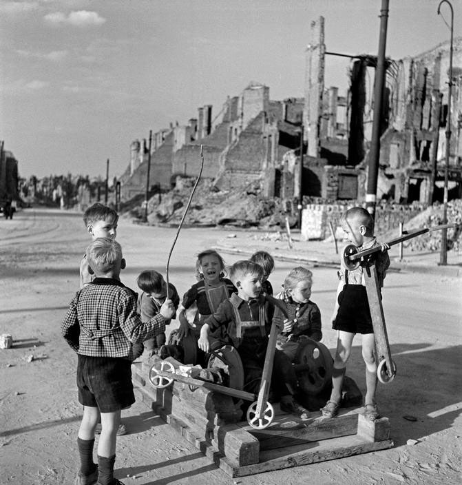 Children playing with their scooters in the ruined streets of the city (Дети, играющие с самокатами на разрушенных улицах города), 1946