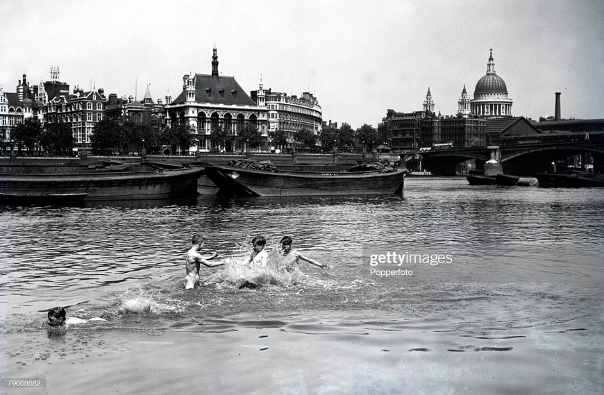 Four young boys enjoying themselves, splashing about in the River Thames on a hot day in London, with the famous St, Paul's cathedral in the background (Четверо мальчишек развлекаются, плескаясь в Темзе в жаркий лондонский день на фоне знаменитого собора Святого Павла.), 1928