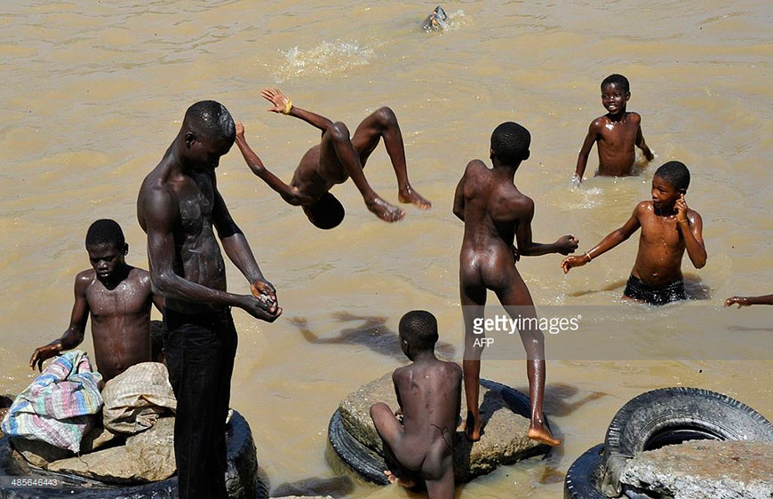 Boys bathe in a polluted body of water that flows through the Ebrie Lagoon, April 2014