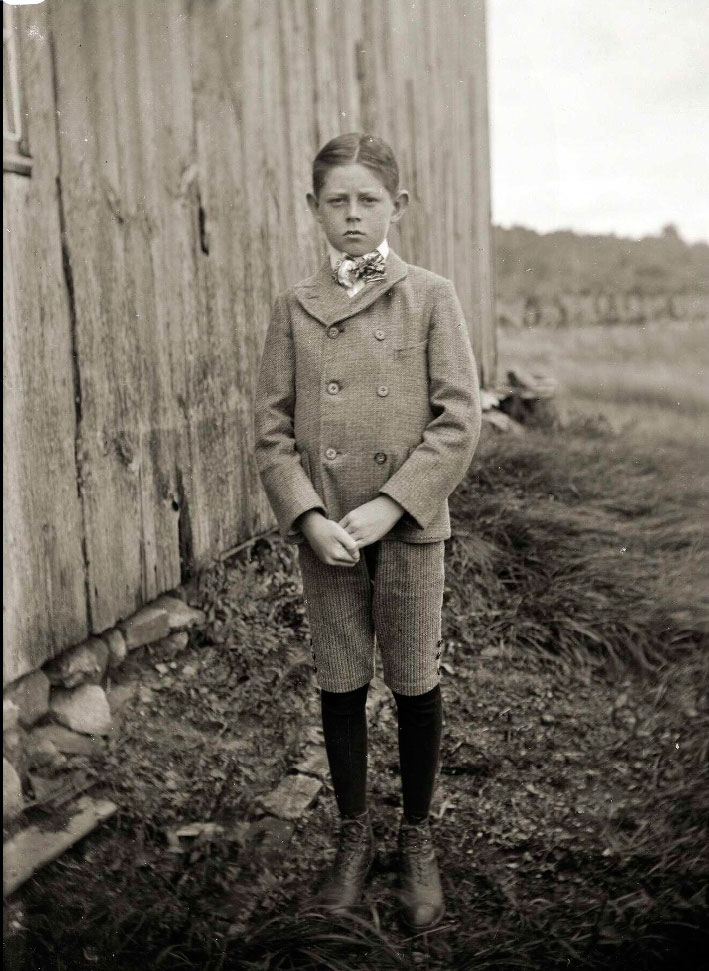 Young boy in good suit, in front of a barn (Мальчик в хорошем костюме, перед сараем), c.1910