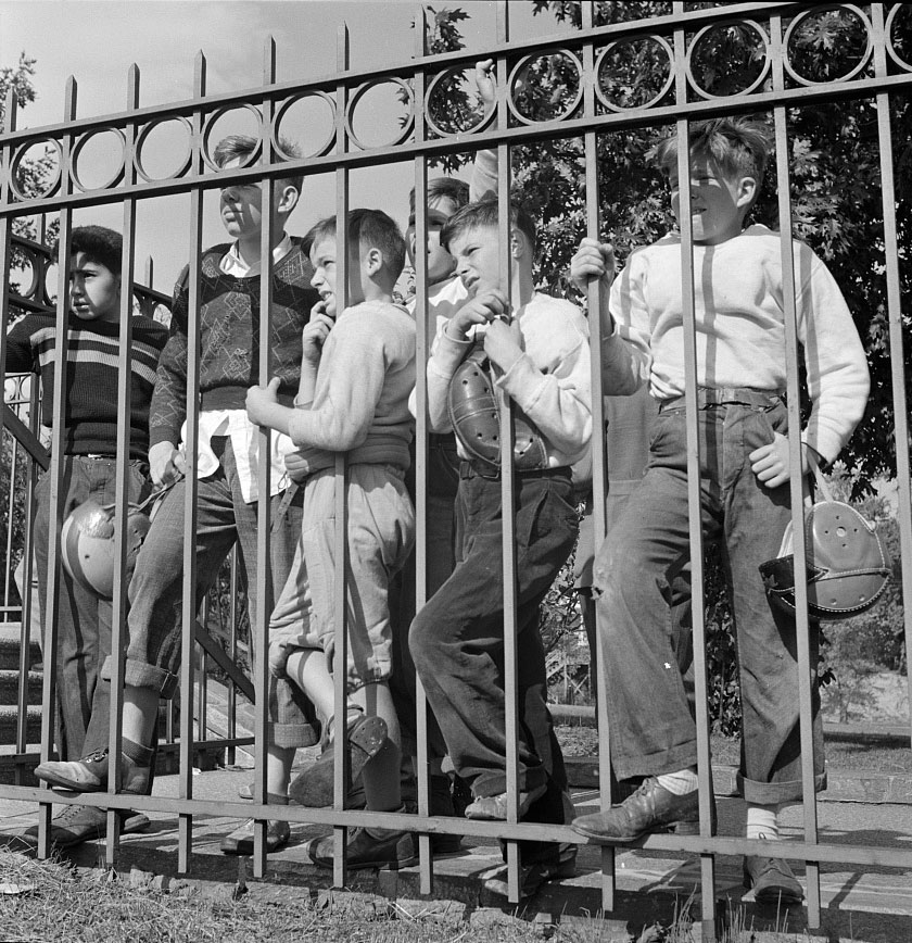 Young Fans Watching High School Football Game Through Fence (Юные фанаты, наблюдающие за футбольной игрой в средней школе через забор), October 1943