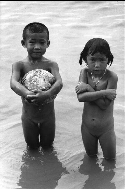 Children use dried out coconuts as 'floats' (Дети, использующие высушенные кокосы в качестве буйков)