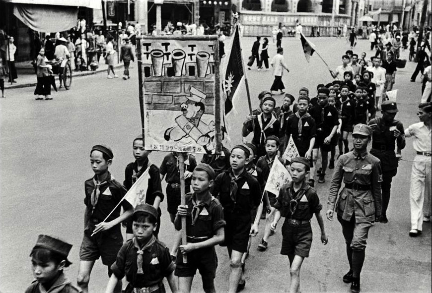 Chinese boy scouts march through city streets carrying anti-Japanese banners during the Sino-Japanese War (Китайские бойскауты маршируют по гордским улицам с анти-японскими плакатами во время китайско-японской войны), 1938