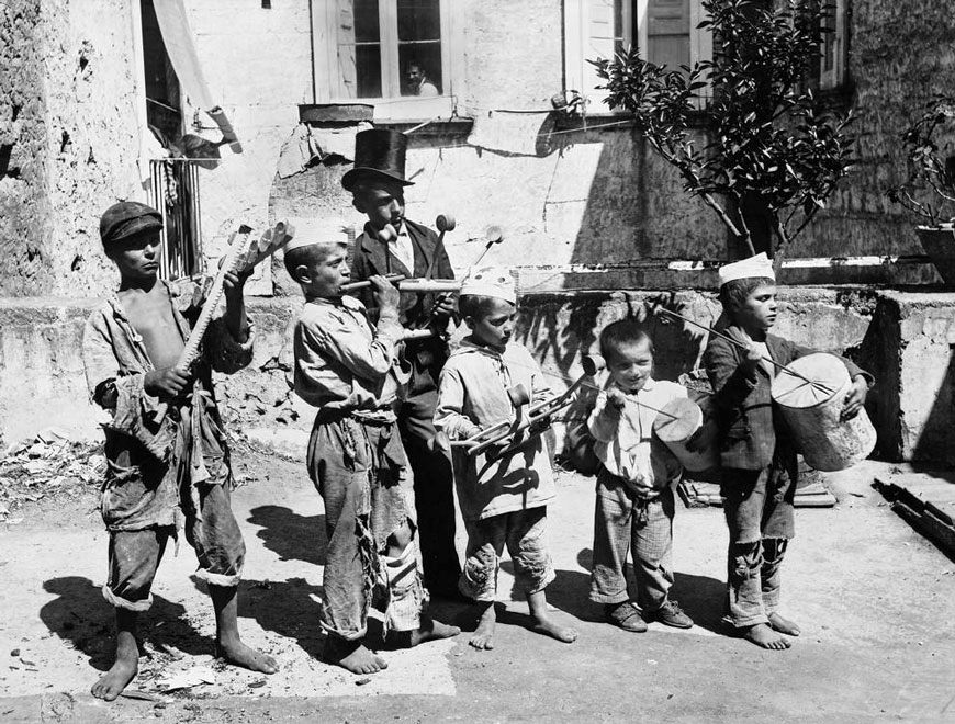 Children with musical instruments (playthings and guaglioni) in a street (Дети с музыкальными инструментами (игрушками и гуаллионами) на улице), c.1890