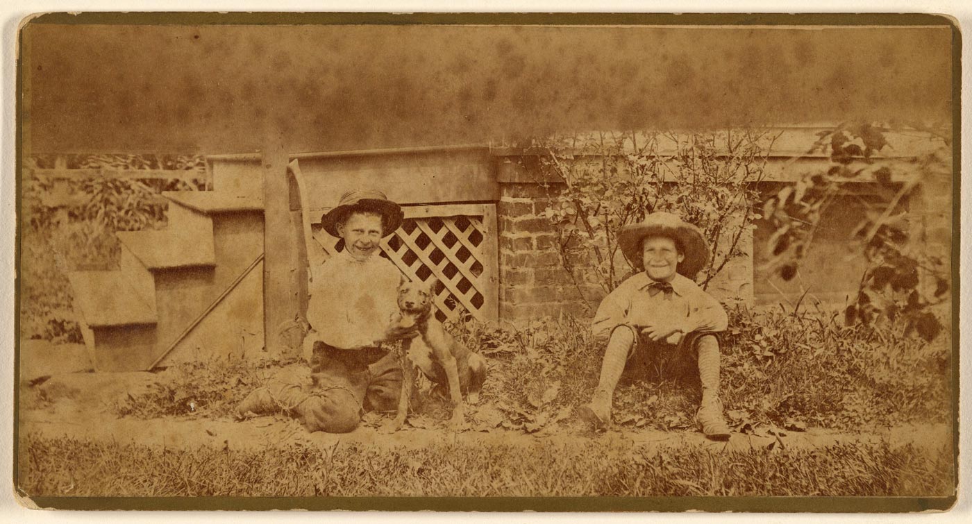 [Two boys seated on ground with a dog / Два мальчика, сидящих на земле с собакой], 1875 