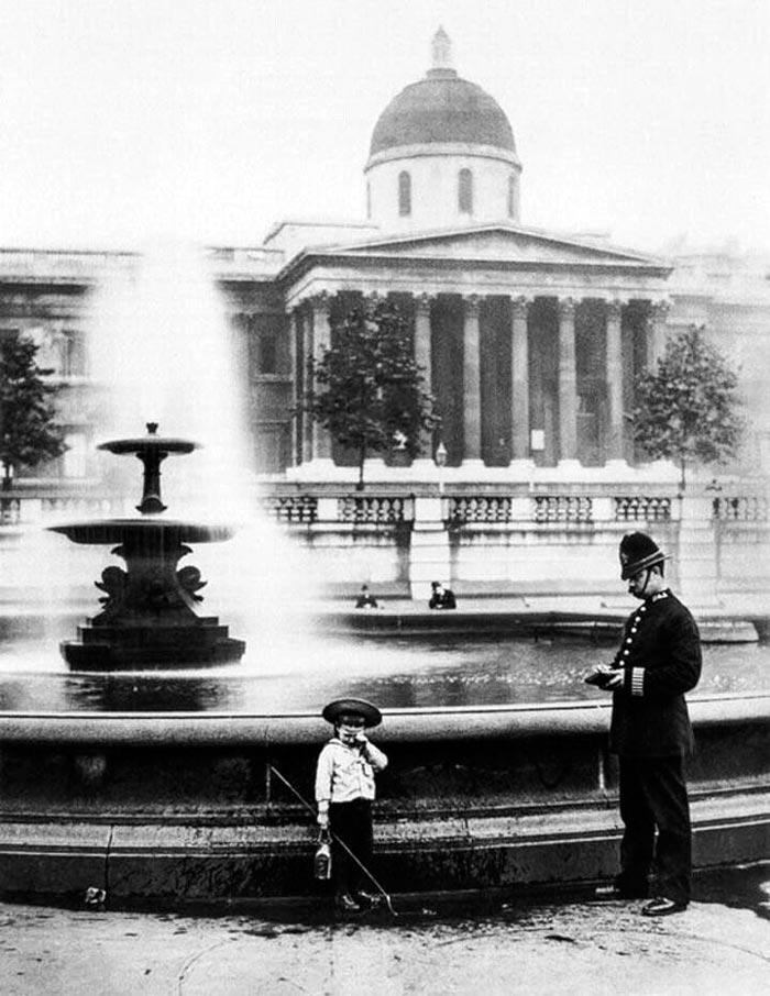 A policeman questions a young boy who probably intended to fish in the fountain on Trafalgar Square (Полицейский допрашивает мальчика, вероятно, собиравшегося порыбачить в фонтане на Трафальгарской площади), 1892