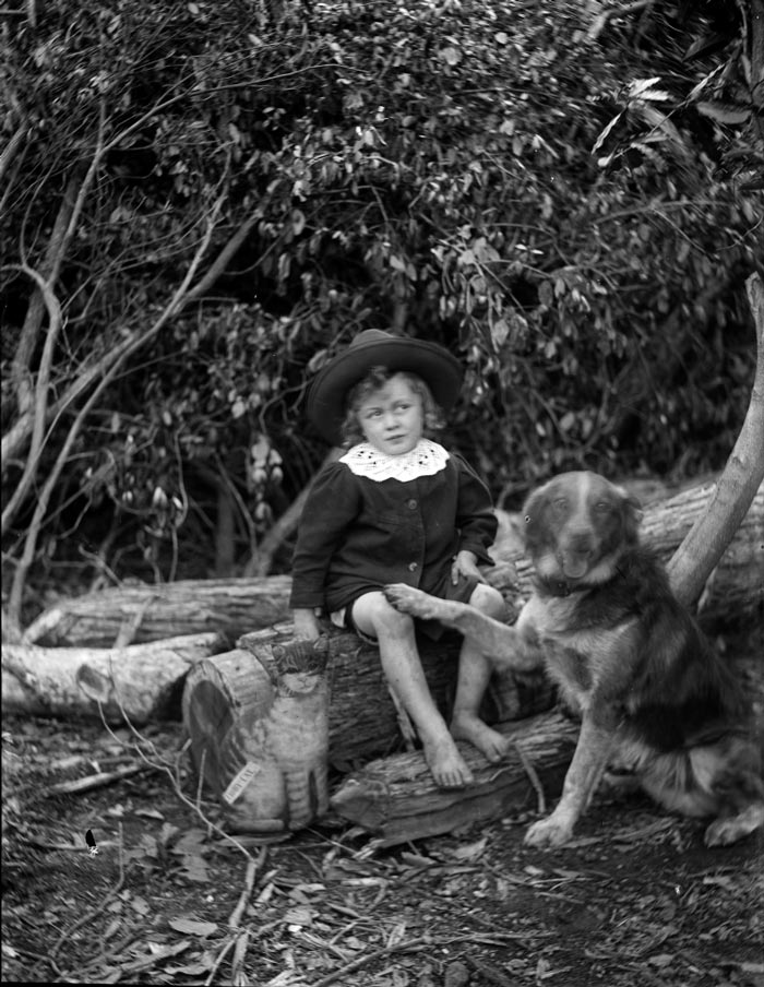 Bare foot boy wearing a hat, seated on a log (Босоногий мальчик в шляпе, сидящий на бревне), c.1900
