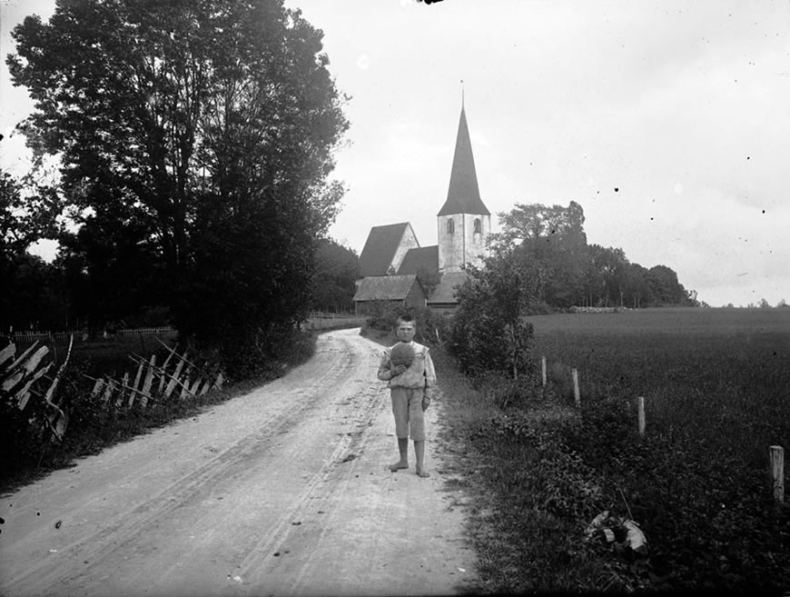 Boy with a ball on the road near Lummelunda Church on the island of Gotland, 1910