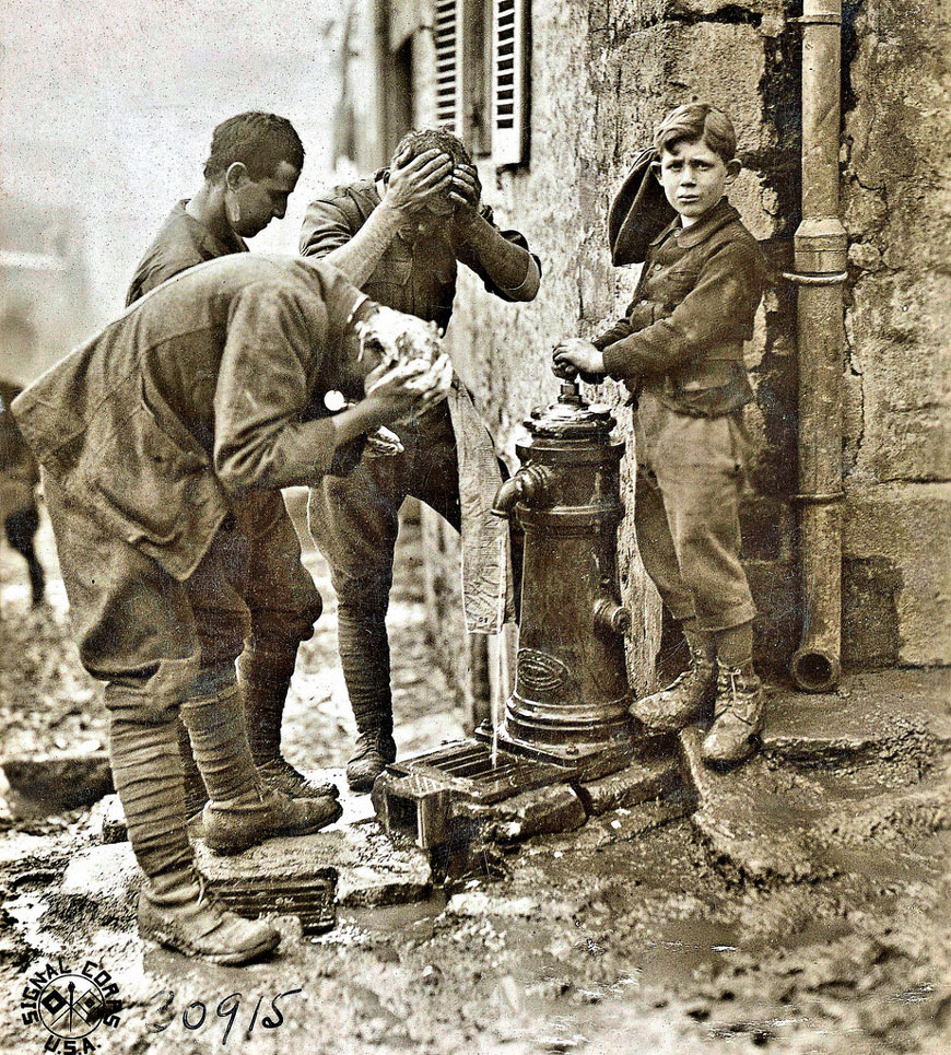 French lad assisting soldiers of the 77th Div. washup (Французский паренёк, помогающий мыться солдатам 77 дивизии США), 11 Oct. 1918