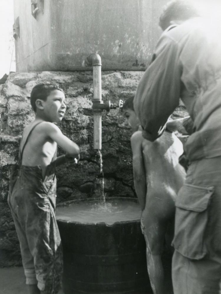 Algerian boys being washing at a water barrel at a French-run military school (Алжирские мальчики моются в бочке с водой во французском военном училище), c.1960