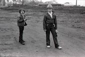 Two boys standing in a muddy lot / Два мальчика, стоящие на грязном участке