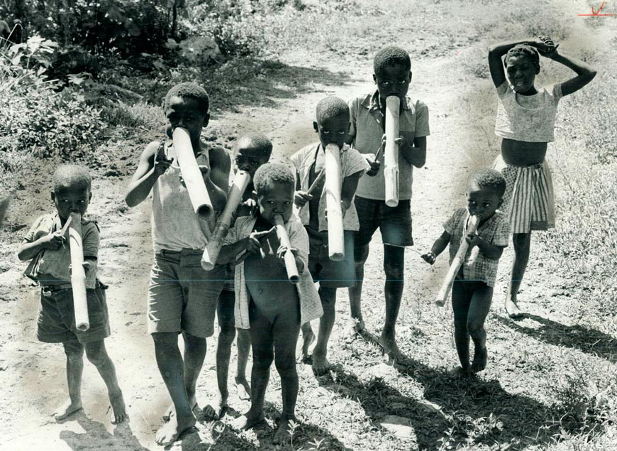 Little Haitian Boys perform an impromptu number on bamboo horns hoping passing tourists will toss them a few coins (Гаитянские мальчишки исполняют импровизированный номер на бамбуковых рожках, надеясь, что проходящие туристы бросят им несколько монет), 1973 Haiti