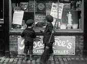 Two children looking at a window of a chocolate shop / Два ребенка заглядывают в витрину шоколадного магазина