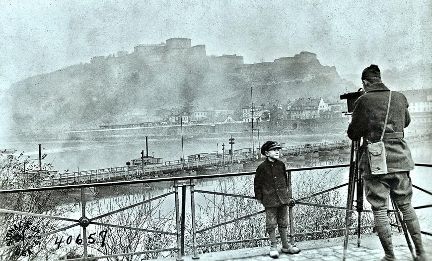 German boy watching American photographer filming Coblentz (Немецкий мальчик наблюдает, как американский фотограф снимает Кобленц.), 1918