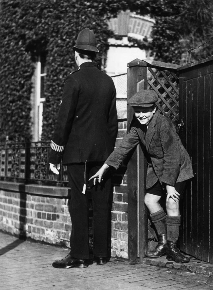 A young boy plays a practical joke on a policeman with a rick-rack firework attached to his jacket (Мальчик шутит над полицейским при помощи петарды, прикрепленной к его форме), 1925