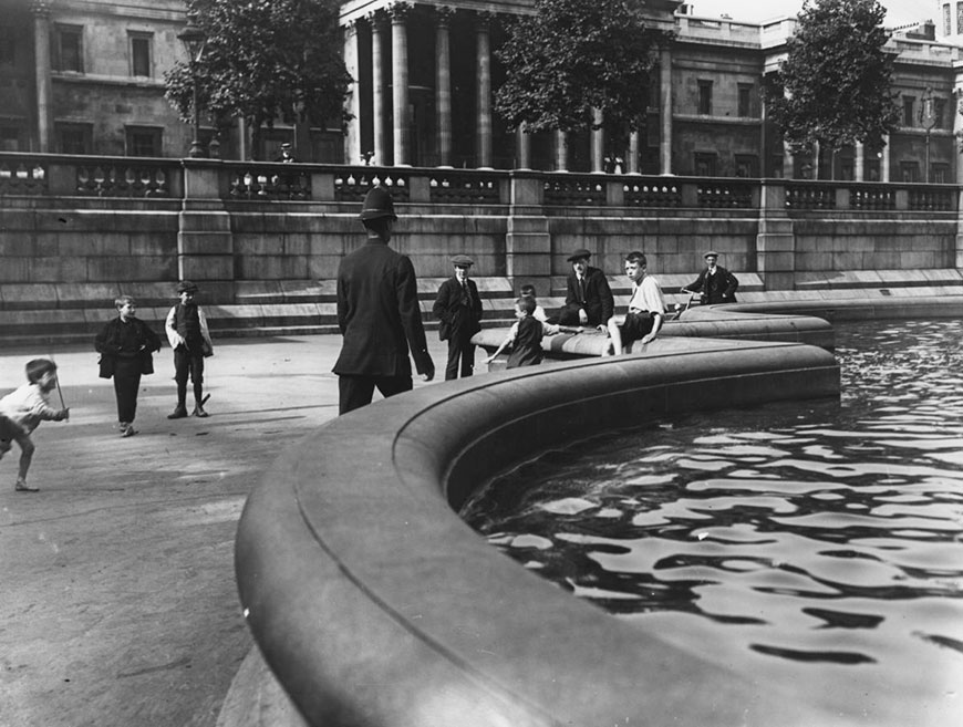 A policeman heading towards a group of children paddling in Trafalgar Square during a heatwave