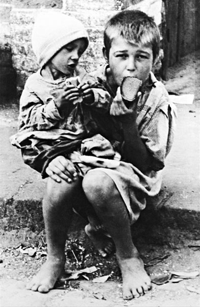 Malnourished children eating bread in the street (Голодные дети, поедающие хлеб на улице)