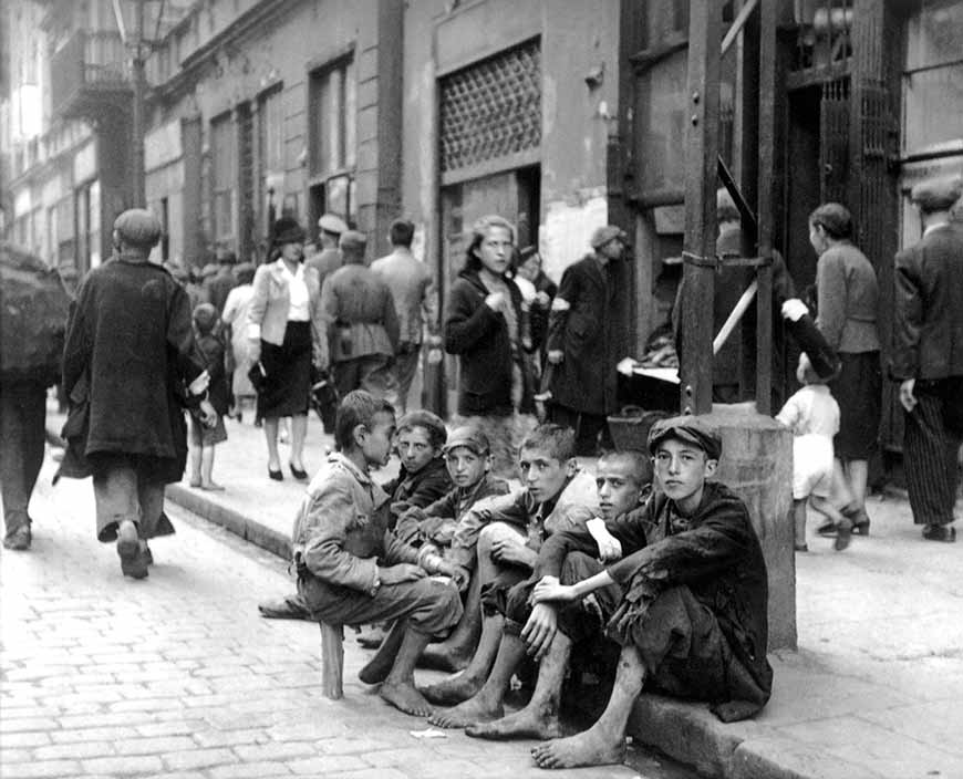 Jewish children sit barefoot and in ragged clothing in Nowolipie Street in the Warsaw Ghetto (Еврейские дети босиком и в рваной одежде, сидящие на улице Новолипие в Варшавском гетто), May 1942