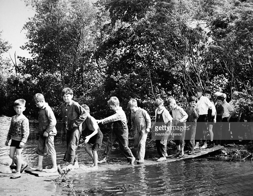 Boys attending summer camp at Winona Lake bridging the old swimmin hole (Мальчики из летниго лагеря на озере Вайнона пересекают старую заводь), 1930