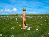 A nude boy standing in the middle of a spiral made of stones in the grass (Обнаженный мальчик, стоящий в траве посреди спирали из камней)