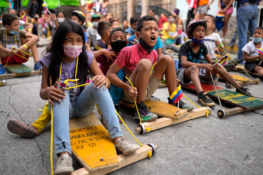 Children enjoy and participate in a traditional street race of 'carruchas' / wooden cars (Дети наслаждаются и участвуют в традиционной уличной гонке «карручас» / деревянных автомобилей), December 2021