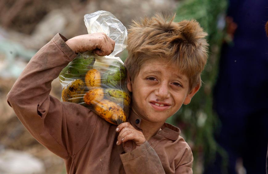 An Afghan refugee boy carries a bag of mangoes on his shoulder (Афганский беженец несет на плече пакет с манго), 2022