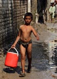 A boy walks along a muddy street after heavy rain / Мальчик идет по грязной улице после сильного дождя