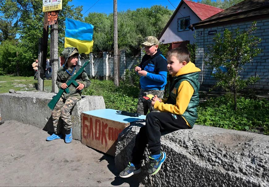 Дети играют в военных на блокпосту в городе Чугуеве (Children play military at a checkpoint in the city of Chuguev), май 2022