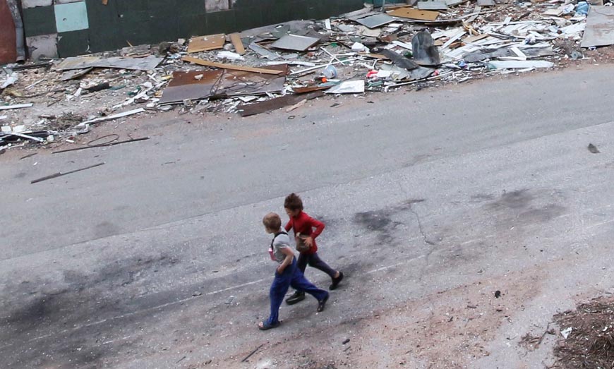 Дети шагают среди разрушенных во время боев зданий (Children walk among buildings destroyed during fighting), 25 May 2022