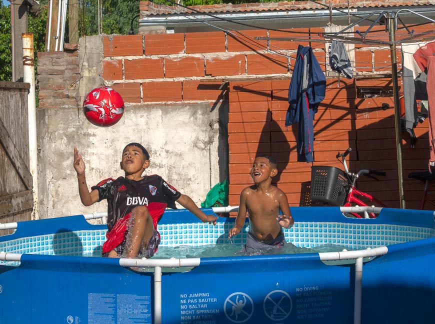 Boys play with a soccer ball inside a pool in their backyard (Мальчишки играют в футбол в бассейне на своём заднем дворе), Nov.2022