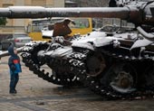 Ребенок смотрит на выставку уничтоженных российских танков / A child looks at a display of destroyed Russian tanks