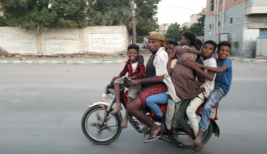 Yemeni man and his children ride a motorcycle down a street (Йеменский мужчина с детьми едет на мотоцикле по улице), 14 February 2023