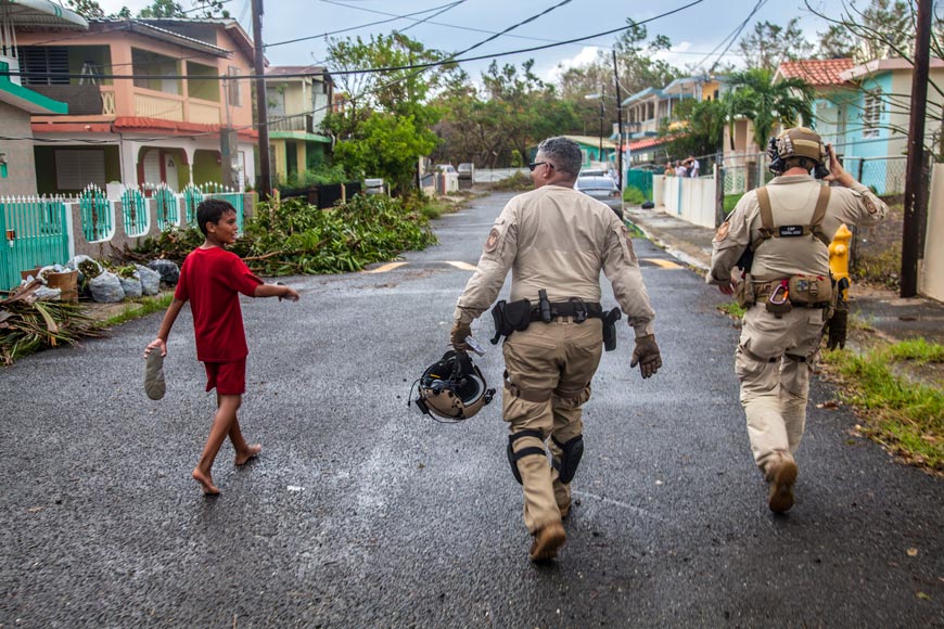 A young boy walks with Air and Marine Operations agents as they walk through a neighborhood checking on residents outside (Мальчик гуляет с агентами ВВС и морской пехоты, проверяющих жителей района), 2017