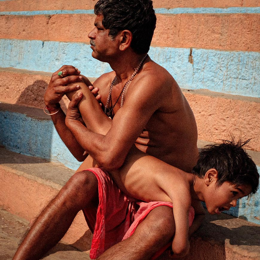 A man making an ayurvedic massage to this boy, after bathing in the Ganga (Мужчина делает аюрведический массаж мальчику после купания в Ганге), 2022