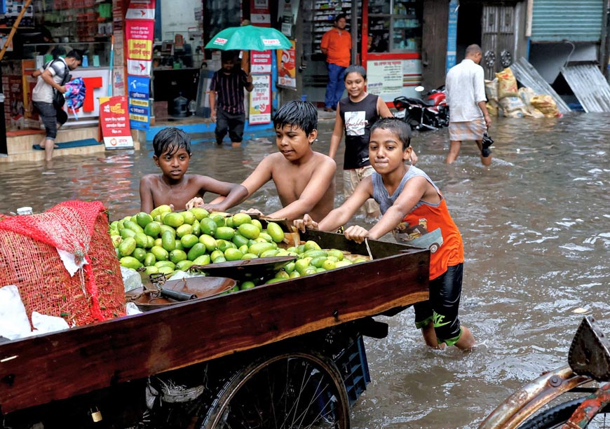 Children push a vegetable seller's cart as streets are flooded amid heavy rains (Дети толкают тележку продавца овощей по улицам, затопленным после сильного дождя), 2023