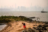 A child stands on the shore before the New York city / Ребенок стоит на берегу перед Нью-Йорком