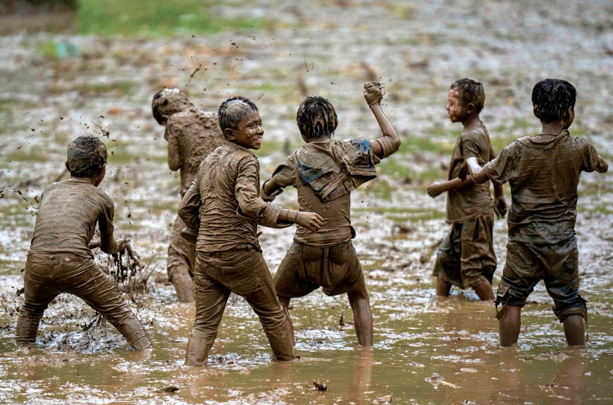 Children play in the mud in a paddy field during Asar Pandra, or paddy planting day (Дети играют в грязи на рисовом поле во время Асар Пандра, или дня посадки риса), 2023 