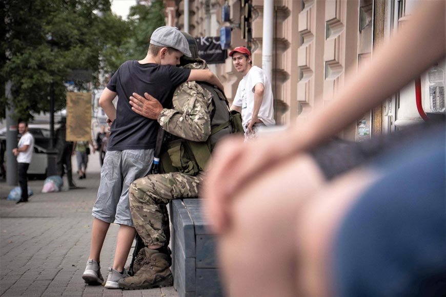 Мальчик обнимается с членом ЧВК Вагнер (A young boy hugs a member of Wagner group), 24 июня 2023 