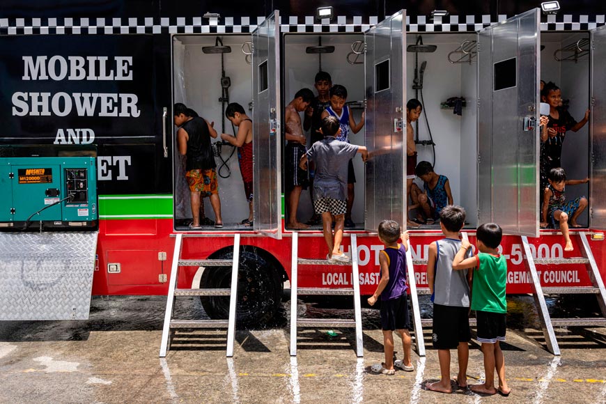 Children use a mobile shower provided by the local government, amid extreme heat (Дети в сильную жару пользуются передвижным душем, предоставленным местным правительством), 2024