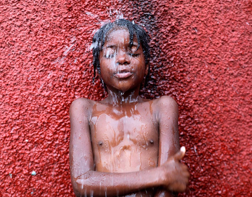 A boy showers at the Ecole Nationale Joseph C. Bernard de Freres where he and others are taking shelter after they had to flee their homes due to gang violence (Мальчик принимает душ в Национальной школе имени Жозефа К. Бернара де Фрера, где он и другие нашли убежище после того, как им пришлось покинуть свои дома из-за насилия со стороны банд), 2024