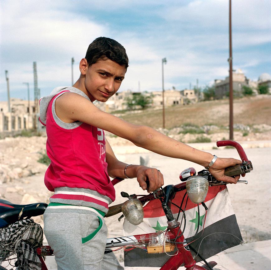 Adolescent on bike with Syrian flag (Подросток на велосипеде с сирийским флагом)