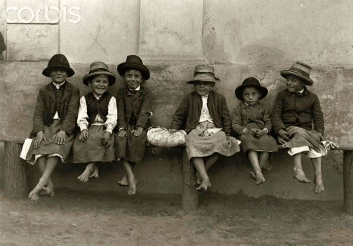 Young boys sit on a bench wearing hats and apron covered trousers (Мальчики, сидящие на скамейке в головных уборах и фартуках, закрывающих штаны), Mike-percs, Hungary