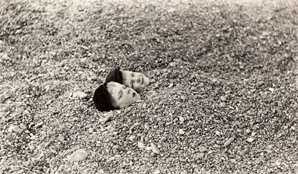 Two boys lay buried under pebbles as a form of amusement on the beach (Два мальчика лежат, засыпанные галькой в качестве развлечения на пляже Брайтона)